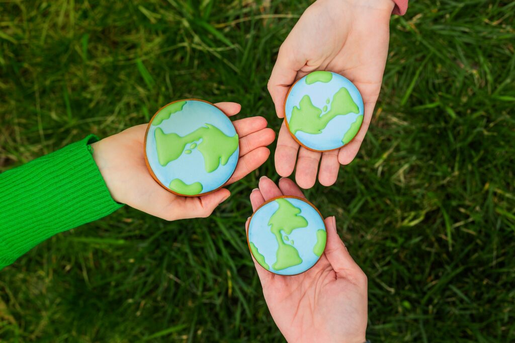 Earth Day concept. Hands hold gingerbread in the shape of the Earth. Care for the environment.